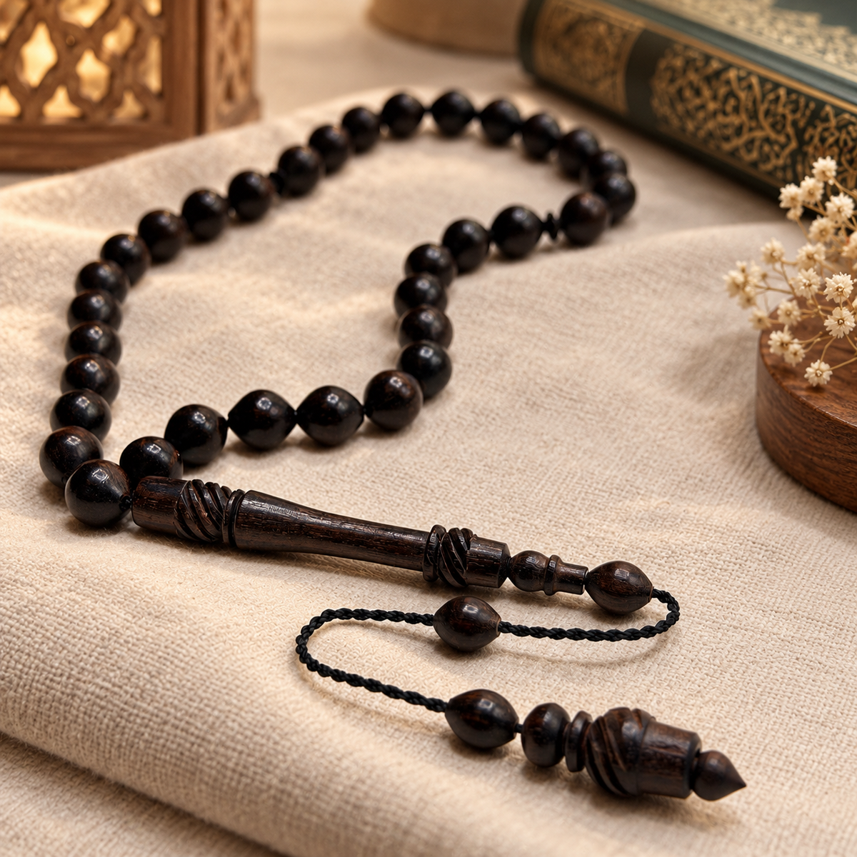 Handmade ebony 33 bead Tasbih arranged beside a Qur'an and lantern