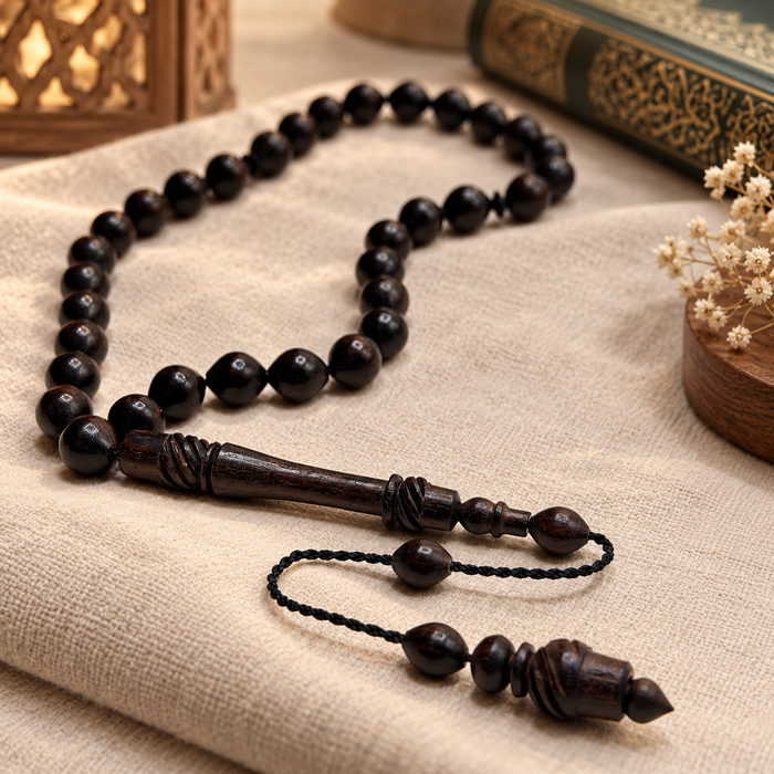 Handmade ebony 33 bead Tasbih arranged beside a Qur'an and lantern