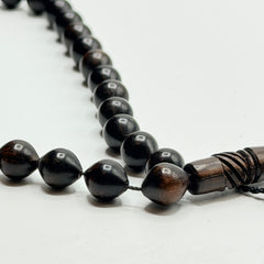 Close view of polished ebony prayer beads and carved wooden imame