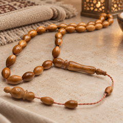 Handmade Kuka wood 33 bead Tasbih styled beside a prayer mat and lantern