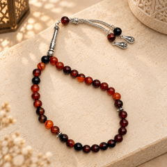 Noir Aqeeq 33 bead Tasbih styled in warm natural light