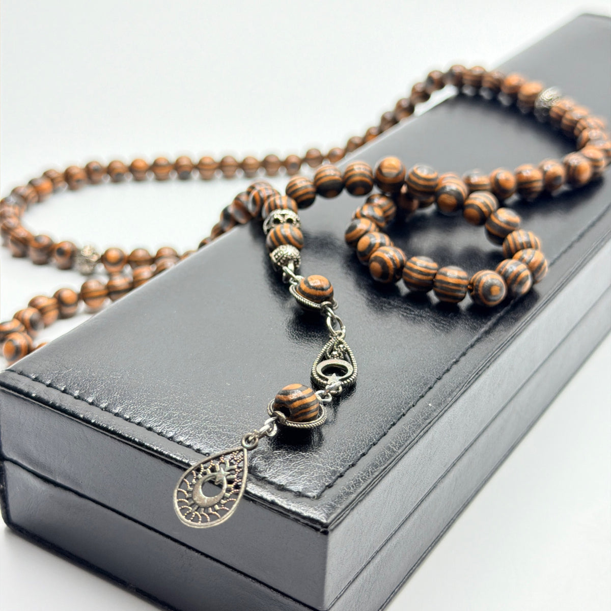 Close view of handmade Kafur camphor wood prayer beads and decorative metalwork