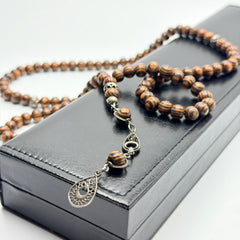 Close view of handmade Kafur camphor wood prayer beads and decorative metalwork