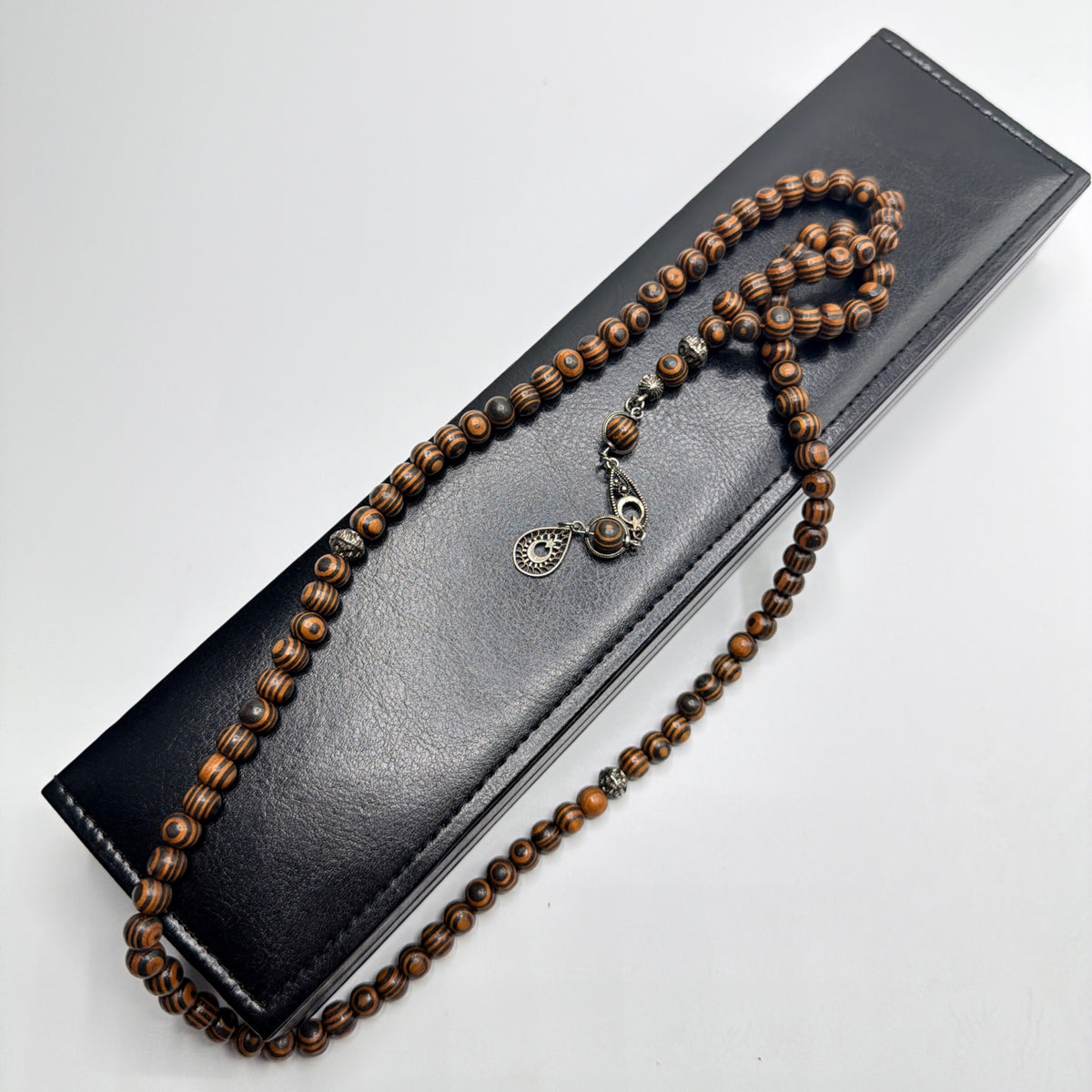 Kafur camphor wood 99 bead Tasbih displayed over the closed luxury leather box