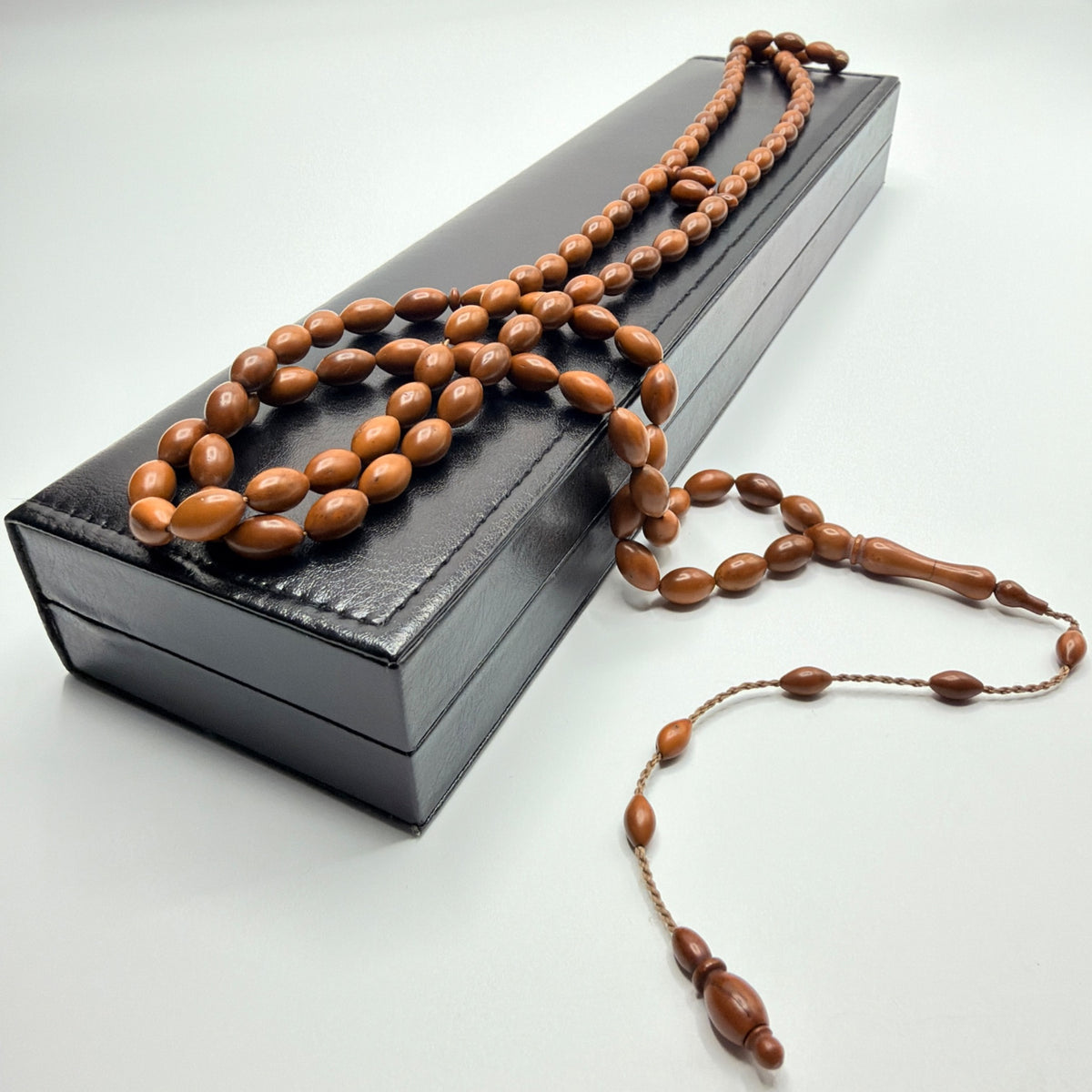 Full length handmade Kuka wood prayer beads displayed across the leather gift box