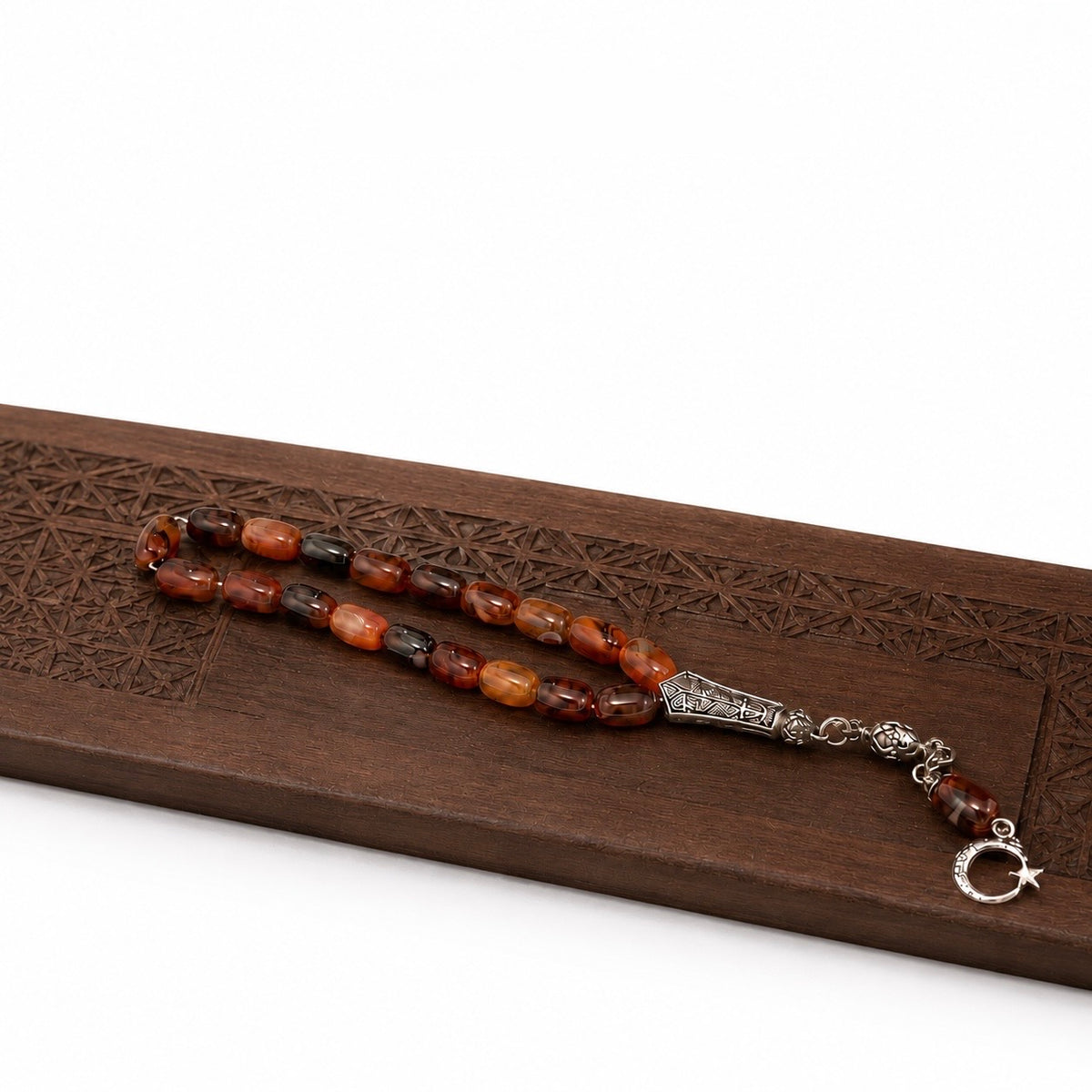 Natural agate Aqeeq Tasbih displayed on a carved wooden presentation surface