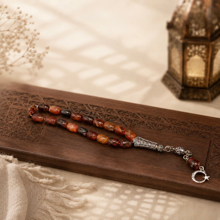 Natural agate Aqeeq Tasbih styled with a lantern and soft natural light