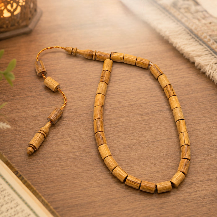 Genuine olive wood Tasbih styled beside a prayer mat and Qur'an