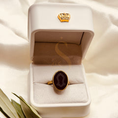 Oval Nalain Mubarak black aqeeq ring presented in a white Sakinah ring box