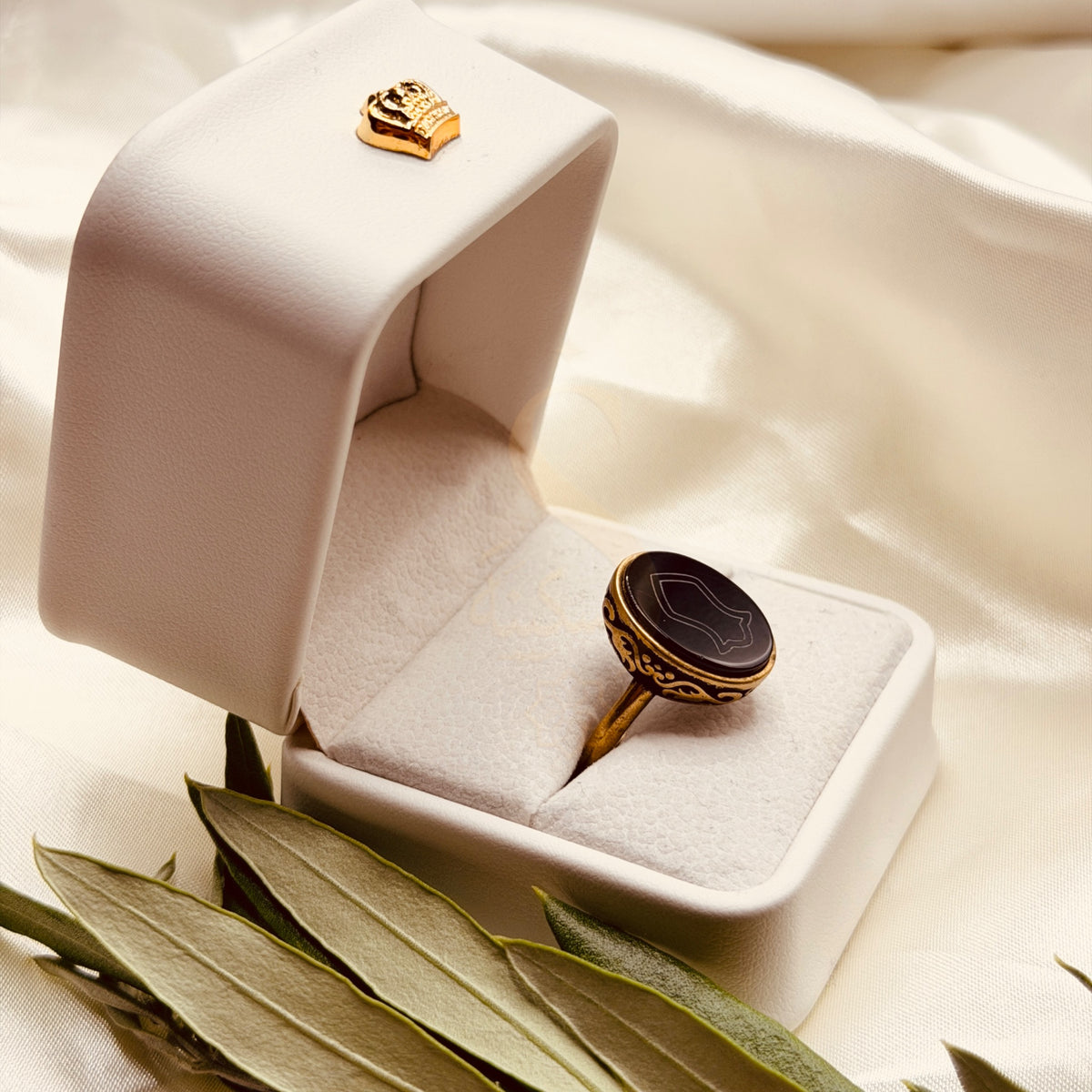 Angled view of the black aqeeq ring and its antique gold tone setting