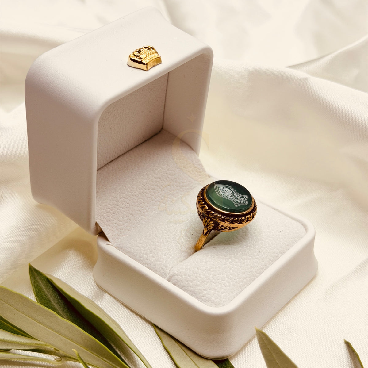 Angled view of the green aqeeq ring and its antique gold tone setting