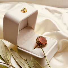 Angled view of the red aqeeq ring and its antique gold tone setting