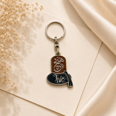 Hıç keychain with brown and black enamel design in silver-tone metal
