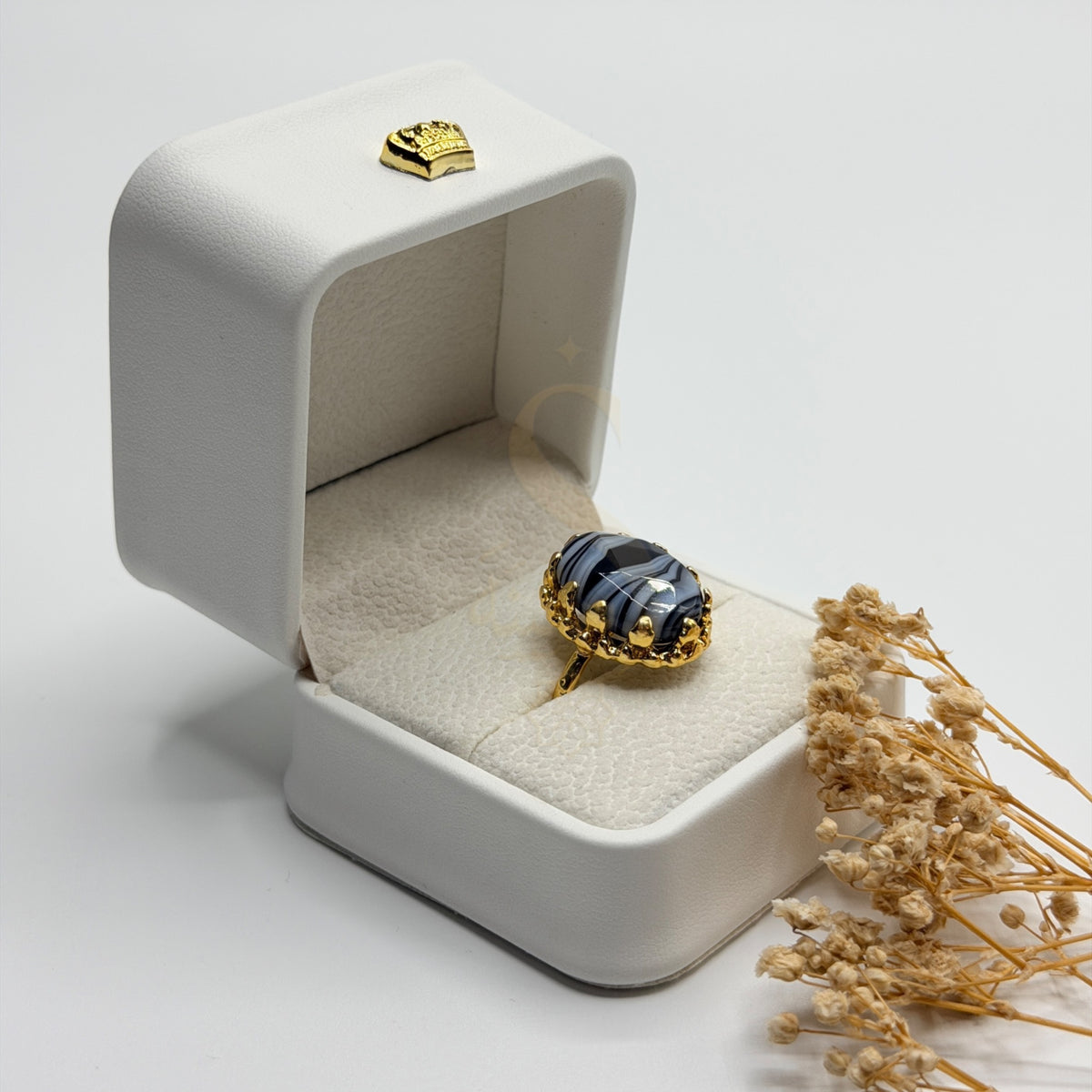 Side view of the banded black and white Sulemani Aqeeq and ornate gold plated setting