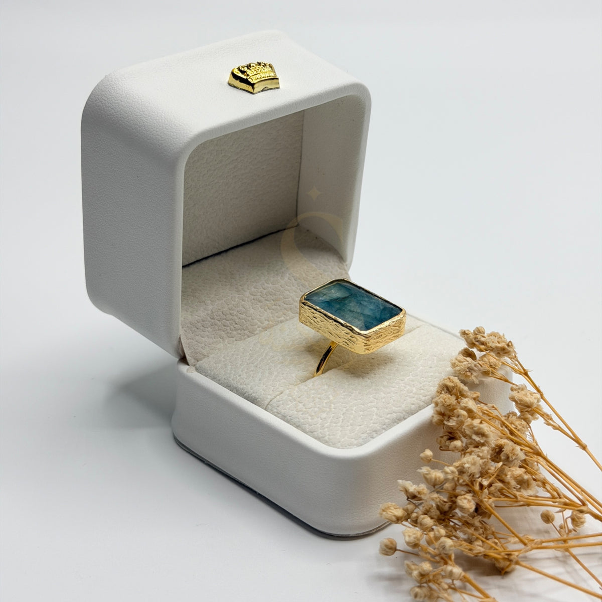 Side view of the rectangular Blue Green Apatite stone and textured gold plated setting
